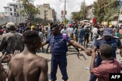 FILE - Congolese policemen try to prevent protesters from reaching the border between Democratic Republic of Congo and Rwanda during clashes with demonstrators in Goma on June 15, 2022.