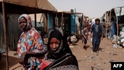 La gente camina por el mercado en el campamento de M'Berra en Bassikounou, Mauritania, el 7 de junio de 2022.