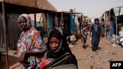 FILE - People walk through the weekly market in M'Berra camp in Bassikounou on June 7, 2022. M'Berra camp, in South East Mauritania, is one the largest camps in West Africa hosting refugees.