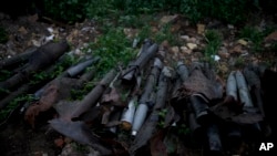 Unexploded shells and other weaponry lay beside a road near Makariv, on the outskirts of Kyiv, Ukraine, Tuesday, June 14, 2022. Russia’s invasion of Ukraine is spreading a deadly litter of mines, bombs and other explosive devices that will endanger civilians long after combat ends.