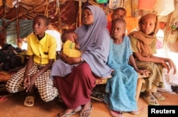 Bashir Nur Salat sits with his mother Meerey Madeey and his siblings during a Reuters interview inside their makeshift shelter at a camp for the internally displaced people in Dollow, Gedo Region, Somalia May 25, 2022. (REUTERS/Feisal Omar)