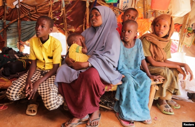 Bashir Nur Salat sits with his mother Meerey Madeey and his siblings during a Reuters interview inside their makeshift shelter at a camp for the internally displaced people in Dollow, Gedo Region, Somalia May 25, 2022. (REUTERS/Feisal Omar)