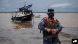 Un soldado hace guardia mientras las autoridades esperan la llegada de las personas que fueron evacuadas de la comunidad de Monkey Point, en el puerto de Bluefields, Nicaragua, el viernes 1 de julio de 2022. (Foto AP/Inti Ocon)