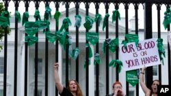 Abortion-rights demonstrators shout slogans after tying green flags to a fence at the White House during a protest to pressure the Biden administration to act and protect abortion rights, in Washington, July 9, 2022.