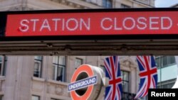 Bendera Inggris dan pengumuman di luar stasiun bawah tanah Oxford Circus pada hari pertama pemogokan kereta api nasional, di London, Inggris, 21 Juni 2022. (REUTERS/John Sibley)