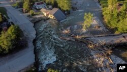 A house sits in Rock Creek after floodwaters washed away a road and a bridge in Red Lodge, Mont., June 15, 2022.