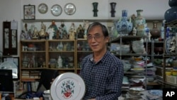 Joseph Tso, owner of Yuet Tung China Works, Hong Kong's last hand-painted porcelain factory, holds a plate with UK royal print in Hong Kong, June 8, 2022. Tso is the third-generation owner of the factory.
