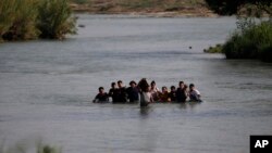 Migrantes, en su mayoría de Nicaragua, cruzan el río Bravo hacia EE UU., en Eagle Pass, Texas, el 20 de mayo de 2022.