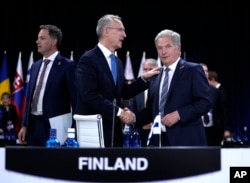 NATO Secretary General Jens Stoltenberg, center, shakes hands with Finland's President Sauli Niinisto, right, during a round table meeting at a NATO summit in Madrid, Spain, June 29, 2022.