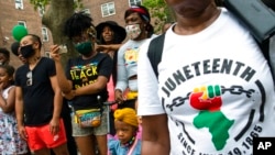 FILE - People attend Juneteenth celebrations in the Harlem neighborhood of New York, June 19, 2021. The movement to recognize Juneteenth, the effective end of slavery in the U.S., as an official holiday in the states has largely stalled.