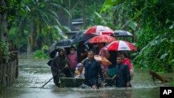 Indian army personnel rescue flood-affected villagers on a boat in Jalimura village, west of Gauhati, India, June 18, 2022.