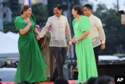 Wakil Presiden terpilih Filipina Sara Duterte, kiri, putri presiden populis Filipina yang akan keluar, disambut oleh Presiden Filipina yang akan datang Ferdinand "Bongbong" Marcos Jr. kedua dari kiri, di Kota Davao, selatan Filipina Minggu 19 Juni 2022. (Foto: AP)