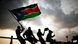 Des Sud-Soudanais brandissent le drapeau national lors du premier match de football national du pays, le 10 juillet 2011, après la déclaration d'indépendance du pays, dans la capitale Juba.