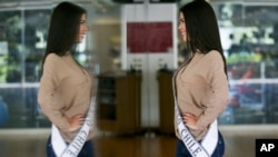 En esta imagen, tomada el 8 de noviembre de 2018, la venezolana Andrea Díaz, Miss Chile, posa delante de un espejo en una clase de modelaje en Santiago, Chile. (AP Foto/Esteban Félix)