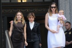 FILE - Gloria Allred, center, representing alleged victims of Jeffrey Epstein, walks with Teala Davies and an unidentified woman and baby after a hearing in the criminal case against Epstein, at federal court in New York, Aug. 27, 2019.