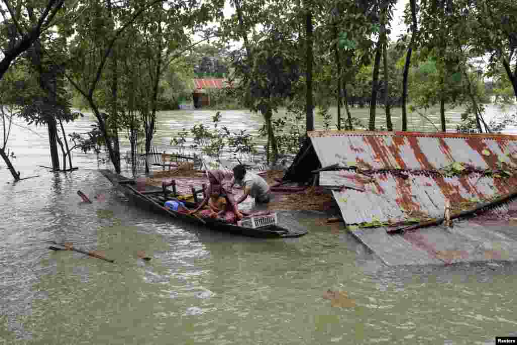 People get on a boat as they look for shelter during a widespread flood in the northeastern part of the country, in Sylhet, Bangladesh.