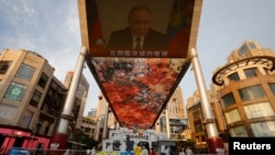 A screen shows a CCTV state media news broadcast of Russian President Vladimir Putin, addressing the BRICS Business Forum via video link, at a shopping center in Beijing, June 23, 2022.