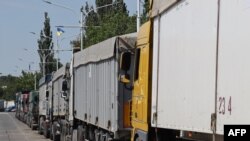 FILE - Trucks loaded with grain wait in a queue near Izmail, in the Odesa region, June 14, 2022.