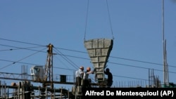 资料照片：这张2009年10月11日的照片显示，中国工人正在浇筑水泥，他们正在建造一个由阿尔及利亚政府资助、由一家中国国有公司在阿尔及利亚的阿尔及尔附近建造的住房项目。（美联社照片）