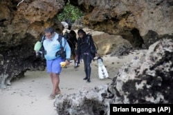 Yatin Patel leads his team to the Indian Ocean in Shimoni, Kenya, June 13, 2022. (AP Photo/Brian Inganga)