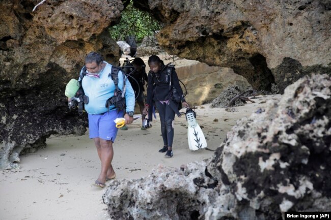 Yatin Patel leads his team to the Indian Ocean in Shimoni, Kenya, June 13, 2022. (AP Photo/Brian Inganga)