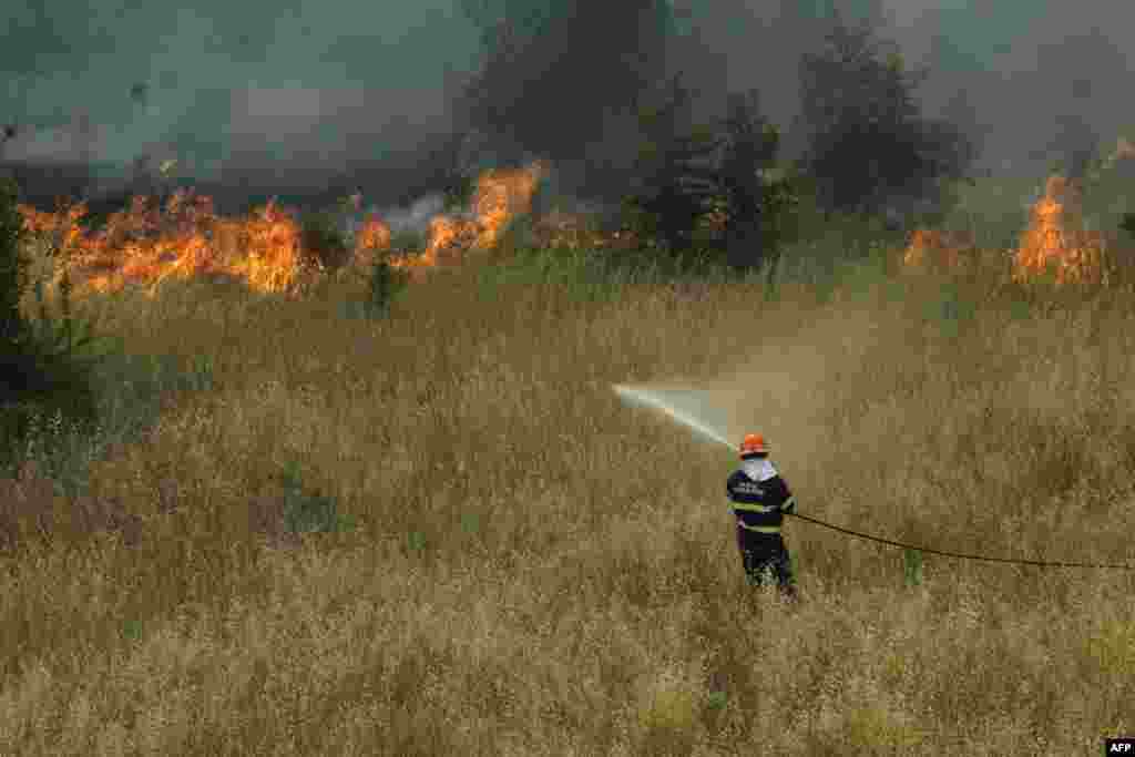 A firefighter sprays water after a fire broke out Via delli Estensi in Rome, Italy.