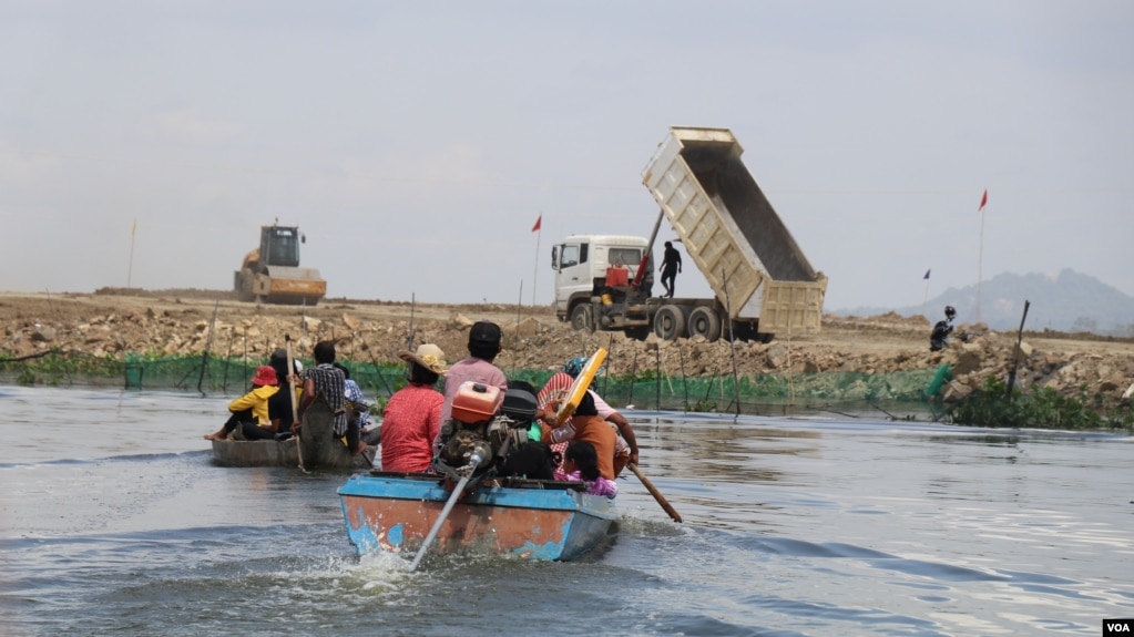 រូបឯកសារ៖ ប្រជាពលរដ្ឋជិះទូក​ទៅកាន់​កន្លែង​គ្រឿង​ចក្រ​កំពុង​ចាក់​ថ្ម​ចូល​បឹង​តាមោក ដែល​ចំ​កន្លែង​ពួកគេ​ចិញ្ចឹម​ត្រី ក្នុង​សង្កាត់​សំរោង​ត្បូង​ ​ខណ្ឌ​ព្រែក​ព្នៅ​ ​រាជ​ធានី​ភ្នំពេញ ថ្ងៃទី២៧ ខែមិថុនា ឆ្នាំ២០២២។ (ហាន ណូយ/វីអូអេ)