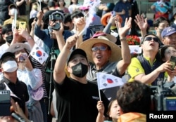21일 한국 전라남도 고흥군 나로우주센터에서 누리호 발사 성공을 지켜본 시민들이 환호하고 있다.