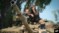 A Ukrainian soldier flashes the victory sign atop a tank in Donetsk region, Ukraine, June 20, 2022. 