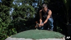 Residents' association President Otavio Barros works on the gas outlet of the sewage treatment biosystem of the Enchanted Valley sustainable community on the outskirts of Tijuca National Forest in Rio de Janeiro, Brazil, June 6, 2022.