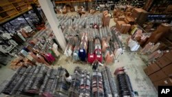 Nadia Zanola, right, chairman of the Cose di Maglia and owner of the D. Exterior brand, goes through racks of clothing at a warehouse section of unsold clothes, in Brescia, Italy, June 14, 2022.