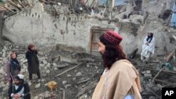 In this photo released by a state-run news agency Bakhtar, Afghans look at destruction caused by an earthquake in the province of Paktika, eastern Afghanistan, Wednesday, June 22, 2022. (Bakhtar News Agency via AP)