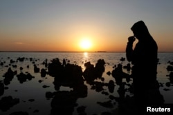 FILE - A man stands next to Sawa lake in Samawa, 270 km (160 miles) south of Baghdad February 22, 2013. One of the most well-known lakes in Iraq, Lake Sawa, is a large closed body of salt water situated in the desert between Baghdad and Basra. The lake is