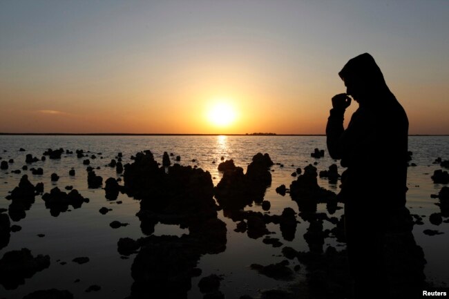 FILE - A man stands next to Sawa lake in Samawa, 270 km (160 miles) south of Baghdad February 22, 2013. One of the most well-known lakes in Iraq, Lake Sawa, is a large closed body of salt water situated in the desert between Baghdad and Basra. The lake is