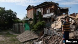 Igor Pidenko stands on the rubble of his neighbour’s house the morning after it was shelled, which buried him and his wife until firefighters were able to free them as Russia’s attack on Ukraine continues in Kharkiv, June 26, 2022. 