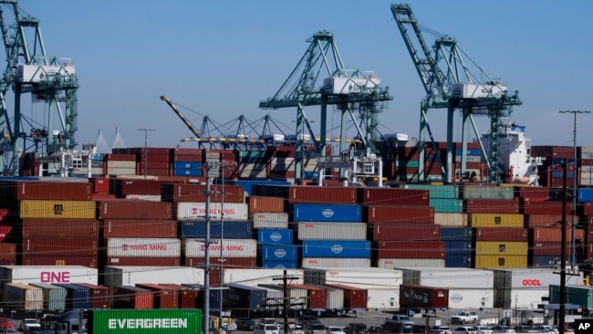 Cargo containers sit stacked at the Port of Los Angeles, on Oct. 20, 2021, in San Pedro, Calif. Dockworkers and shipping companies at 29 ports on the U.S. West Coast say they plan to keep cargo moving as they negotiate a contract. The last one expired Friday.