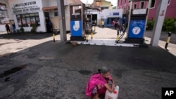 FILE - A Sri Lankan woman waits in a deserted gas station, hoping to buy kerosene oil for cooking in Colombo, Sri Lanka, May 26, 2022. Sri Lanka has run out of fuel, according to a report in Monday's Daily Mirror.