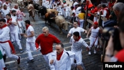 Revelers run during the running of the bulls at the San Fermin festival in Pamplona, Spain, July 7, 2022.