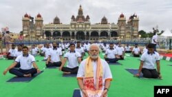 Perdana Menteri India Narendra Modi mengikuti sesi yoga bersama di depan Istana Mysore di Mysore, dalam perayaan Hari Yoga Internasional, 21 Juni 2022. (Foto oleh Manjunath Kiran / AFP)