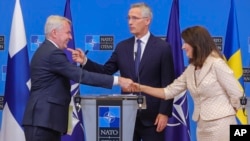 Finland's Foreign Minister Pekka Haavisto, left, Sweden's Foreign Minister Ann Linde, right, and NATO Secretary General Jens Stoltenberg after the signature of the NATO Accession Protocols for Finland and Sweden on July 5, 2022. (AP Photo/Olivier Matthys)