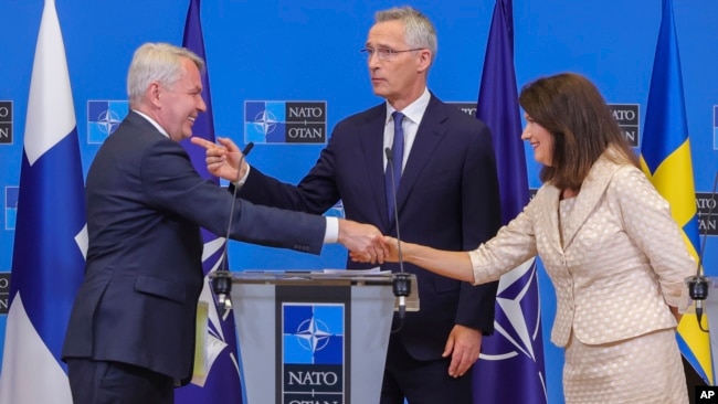 Finland's Foreign Minister Pekka Haavisto, left, Sweden's Foreign Minister Ann Linde, right, and NATO Secretary General Jens Stoltenberg after the signature of the NATO Accession Protocols for Finland and Sweden on July 5, 2022. (AP Photo/Olivier Matthys)