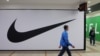 FILE - People walk past a closed store of the sporting goods retailer Nike at a shopping mall in Saint Petersburg, Russia, May 25, 2022. 
