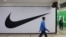 FILE - People walk past a closed store of the sporting goods retailer Nike at a shopping mall in Saint Petersburg, Russia, May 25, 2022. 