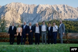 (L-R) Italian Prime Minister Mario Draghi, President of the European Commission Ursula von der Leyen, US President Joe Biden, German Chancellor Olaf Scholz, British Prime Minister Boris Johnson, Canadian Prime Minister Justin Trudeau, Japanese Prime Minister Fumio Kishida, French President Emmanuel Macron and President of the European Council Charles Michel pose for an informal group photo standing at a bench after a working dinner during the G7 Summit held at Elmau Castle, southern Germany on June 26, 2022. (Photo by Ludovic MARIN / POOL / AFP)