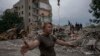 Seorang anngota pasukan Ukraina meminta awak media untuk mundur dari lokasi reruntuhan gedung yang hancur dihantam oleh rudal Rusia di Chasiv Yar, wilayah Donetsk pada 10 Juli 2022. (Foto: AP/Nariman El-Mofty) 