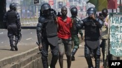 ARCHIVES - Des policiers arrêtent un homme lors d'une manifestation à Conakry, le 14 novembre 2019.