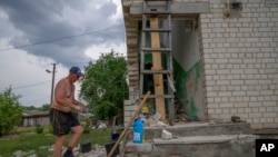 A man rebuilds his home that was destroyed by Russian strikes, in Yahidne village, northern Chernihiv region, Ukraine, June 29, 2022. A few months after Russian troops retreated from Yahidne, the village has gradually returned to life.