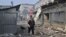 A woman passes by destroyed shops on a local market after a rocket attack in the Ukrainian town of Sloviansk, on July 3, 2022, amid the Russian invasion of Ukraine. 