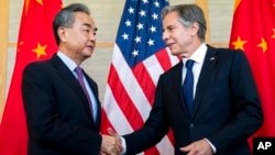 US Secretary of State Antony Blinken, right, shakes hands with China's Foreign Minister Wang Yi during a meeting in Nusa Dua on the Indonesian resort island of Bali, July 9, 2022.