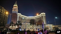 FILE - People walk in front of the Venetian Macao casino resorts in Macao, Nov. 23, 2014. The Asian gambling center of Macao will close all its casinos for a week starting July 11, 2022.